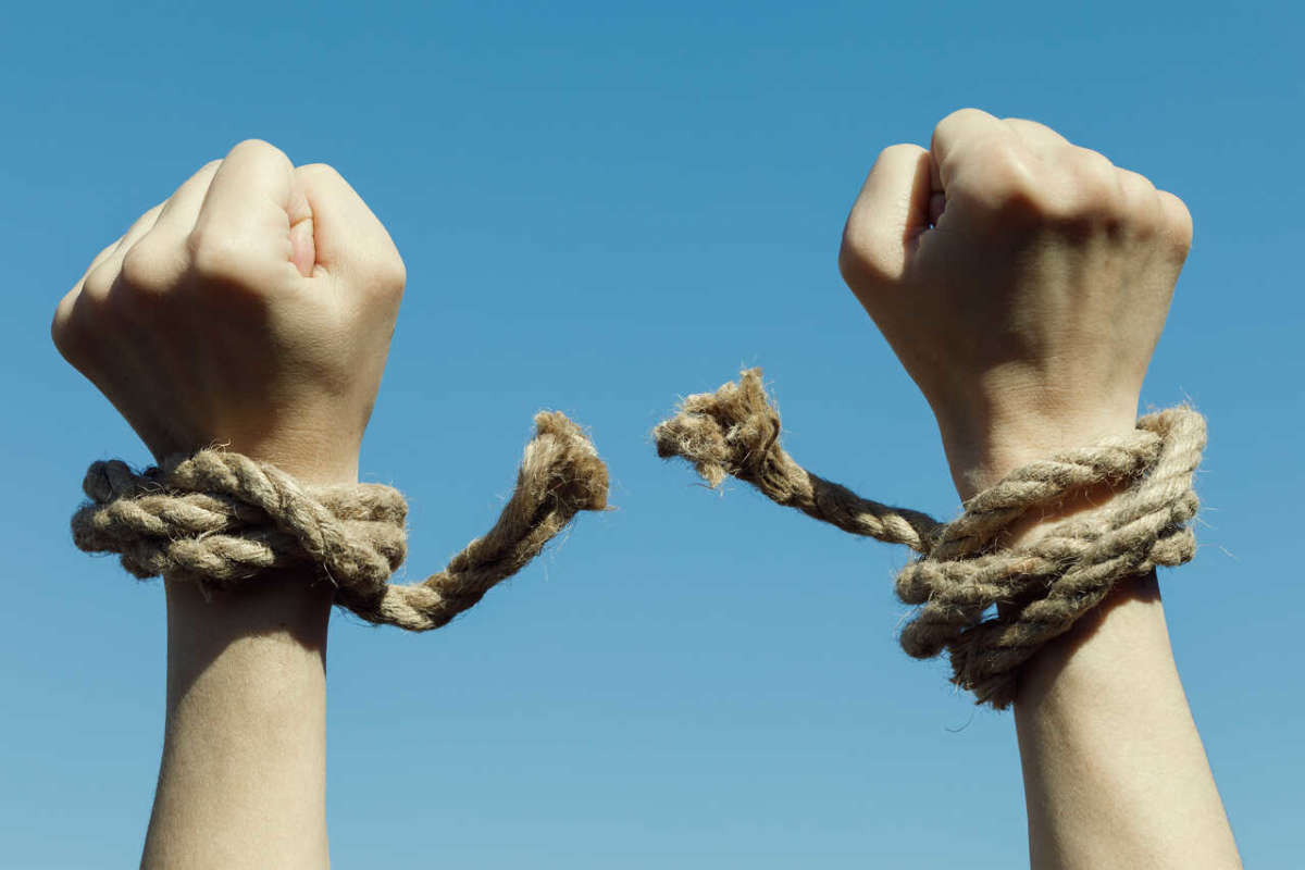 Hands,tearing,shackles,the,background,of,blue,sky.,concept,of